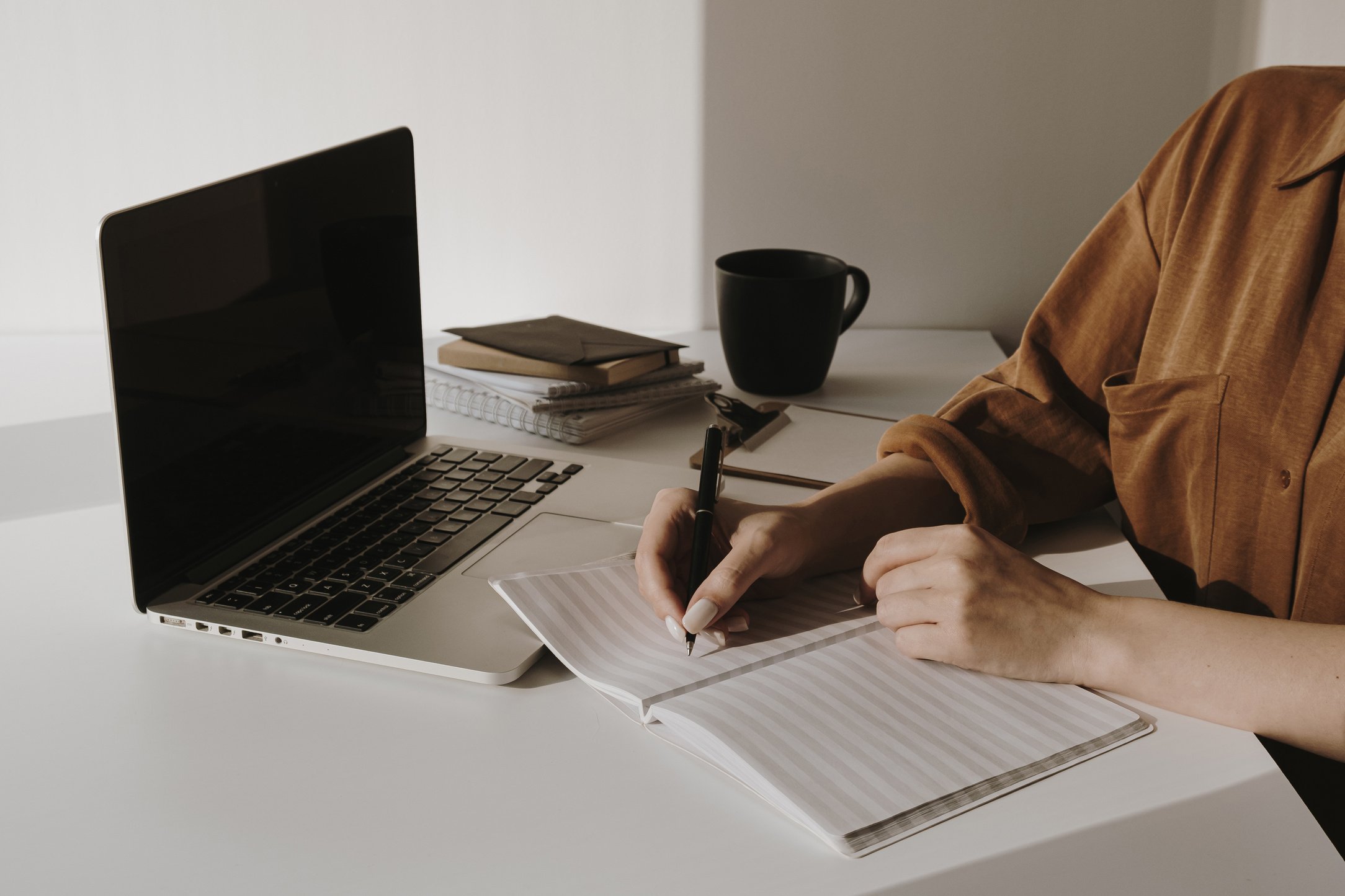 Person Writing on a Notebook